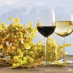 white and red wine on a table with grapes