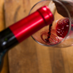 pouring red wine into a glass